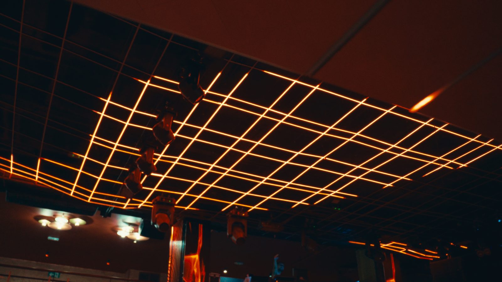 Techo con rejilla de líneas de luz cálida vista desde abajo.